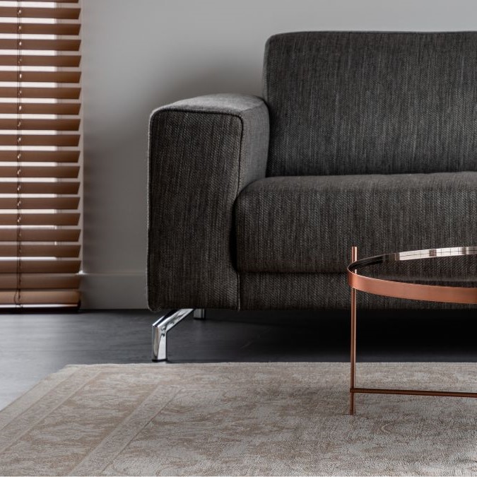 A heavy table on top of a rug on a polished concrete floor.