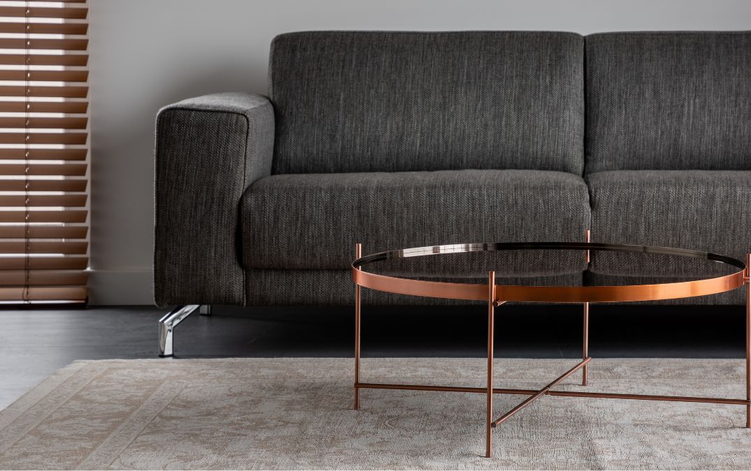 A heavy table on top of a rug on a polished concrete floor.